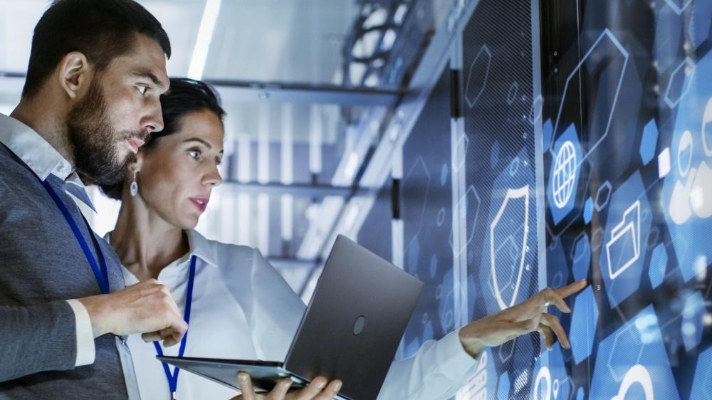 Imagen dos personas ante una pantalla digital
