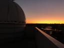 Se ve un atardecer desde la terraza del observatorio, dejando la cúpula a la izquierda