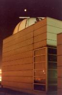 Exterior of the observatory at night, the dome can be seen protruding from the top