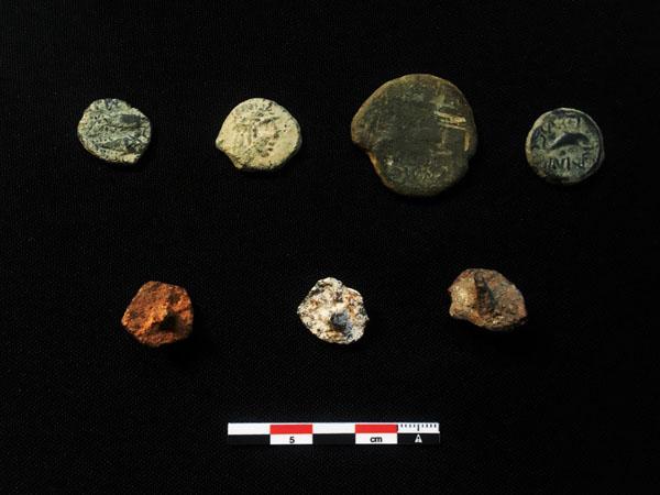 Monedas iberorromanas (superior) y tachuelas de calzado militar (clavus caligaris) (inferior) hallados en el transcurso de las prospecciones.