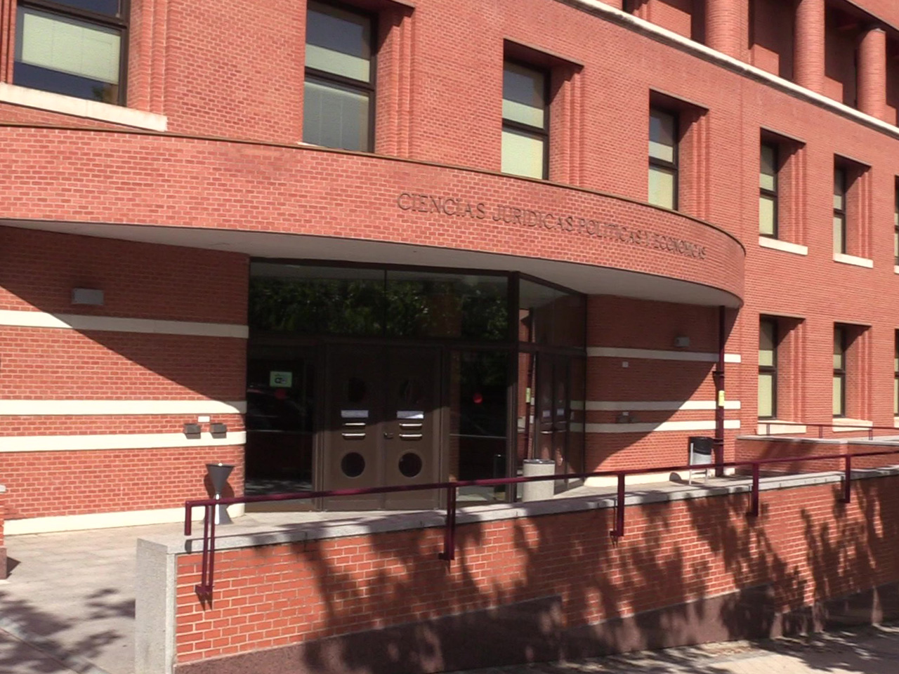 Alumno sentado en el césped de la facultad de ciencias