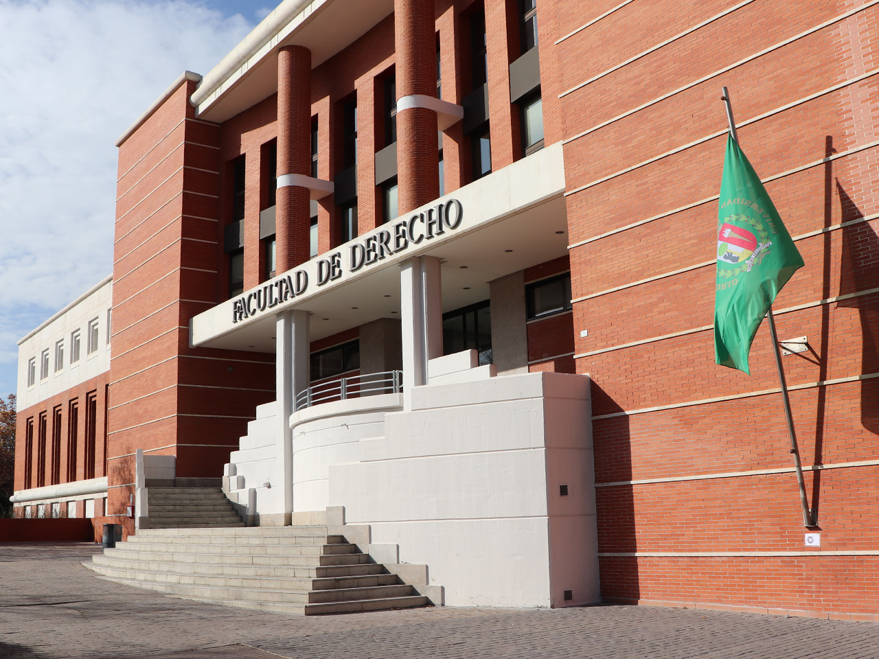 Alumno sentado en el césped de la facultad de ciencias