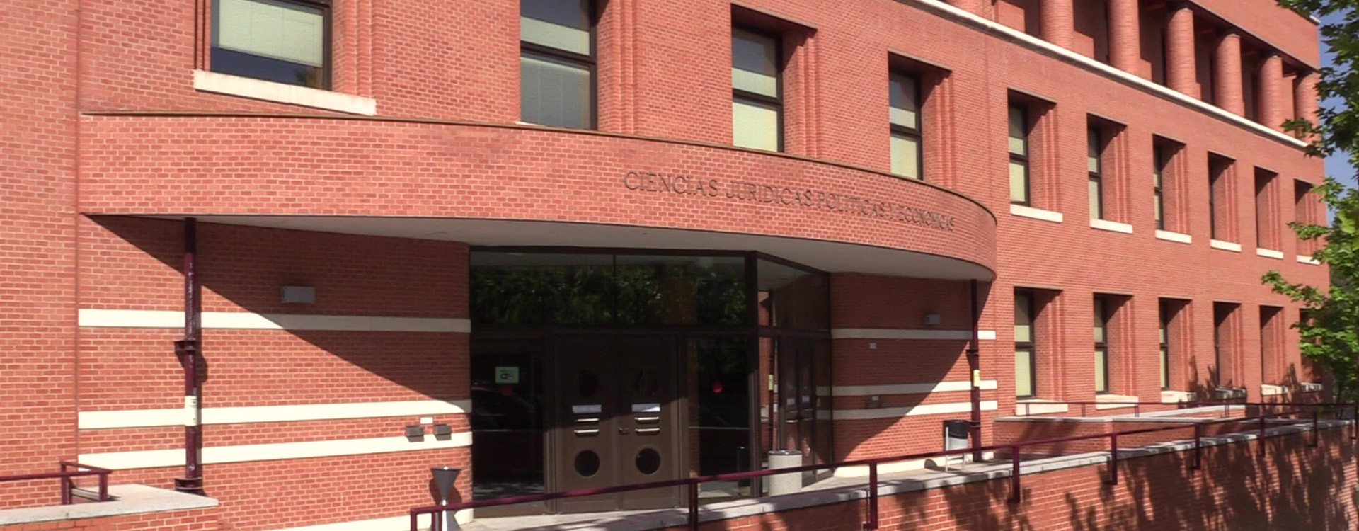 Alumno sentado en el césped de la facultad de ciencias