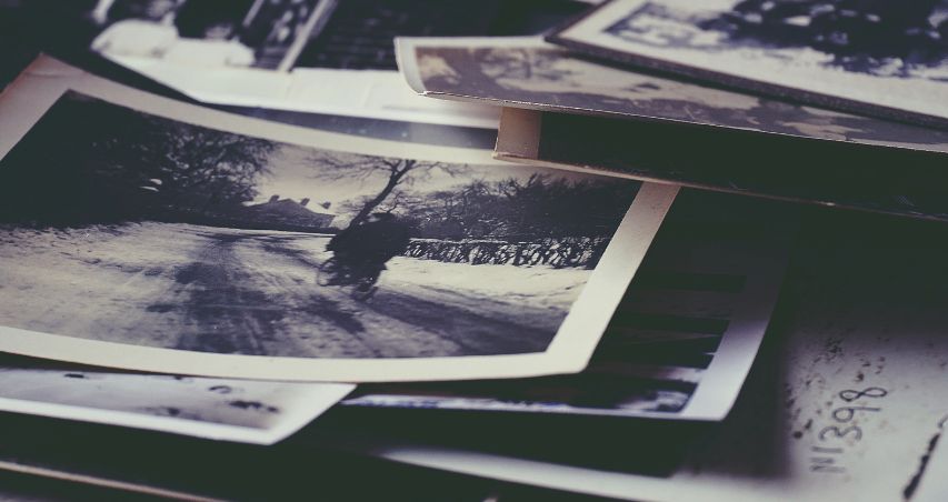 Fotomontaje en blanco y negro de una mesa con un montón de fotografías encima
