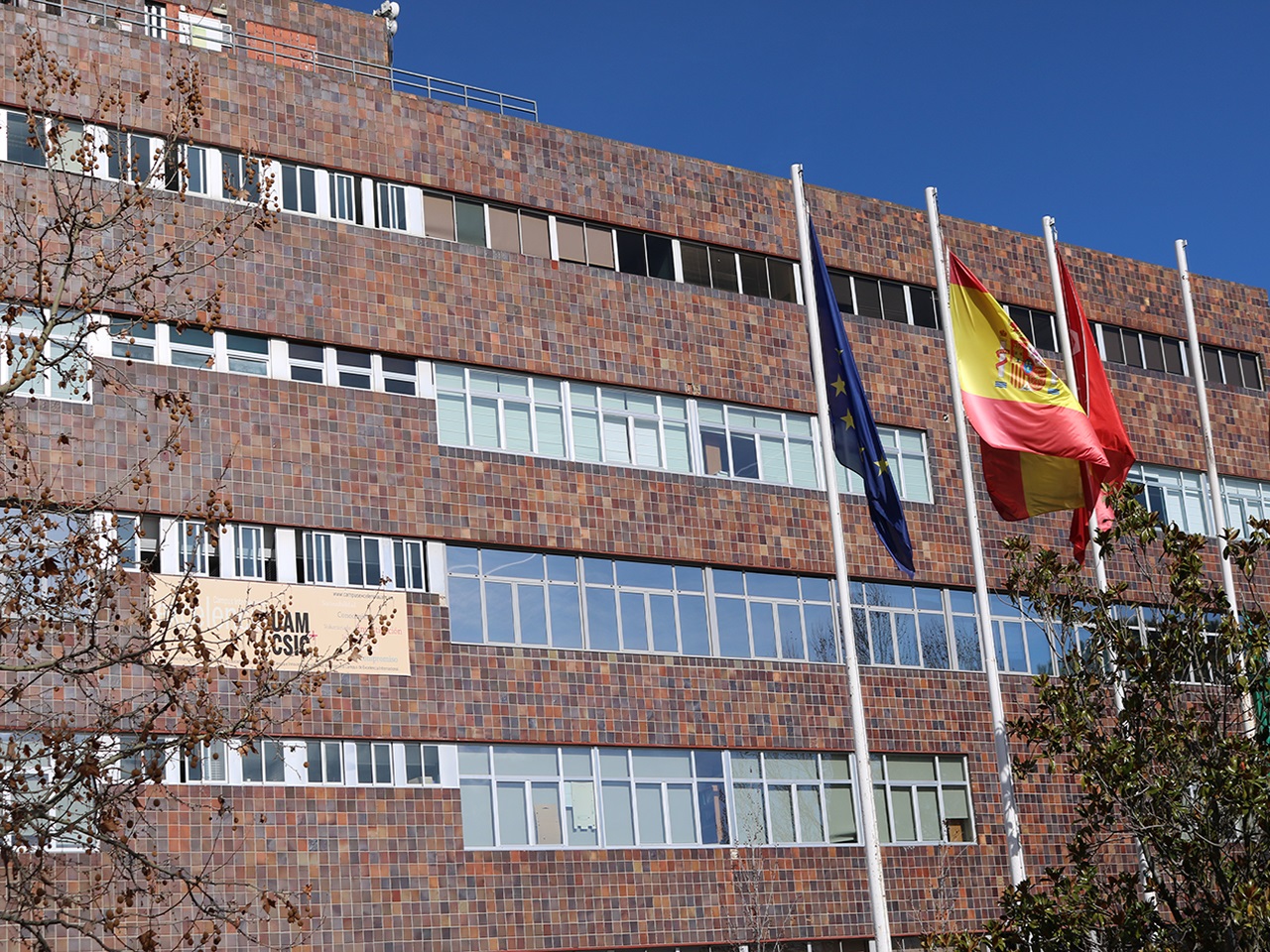 Imagen de la fachada principal del Rectorado de la UAM con banderas en el frente
