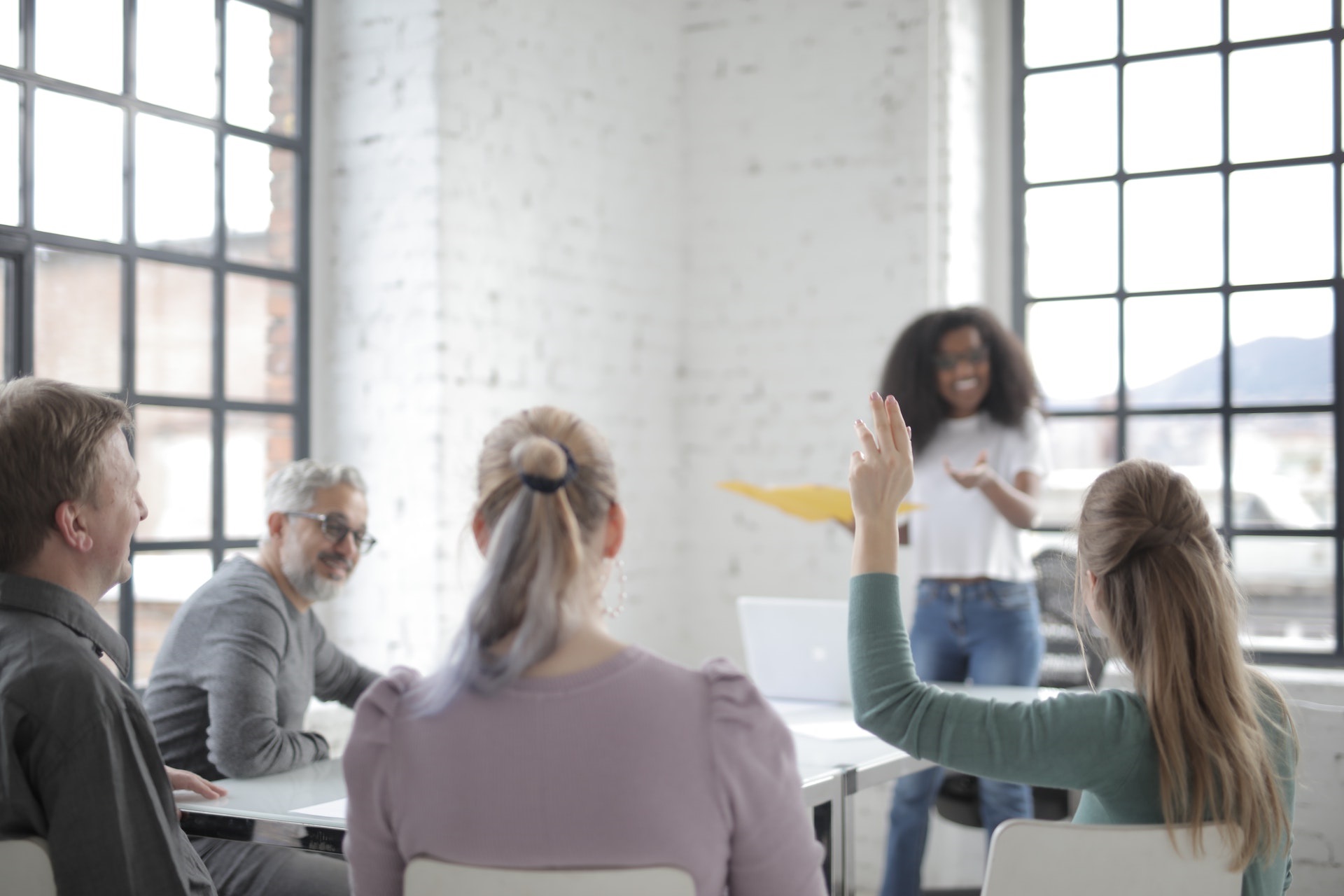 Personas escuchando a mujer dando una charla.