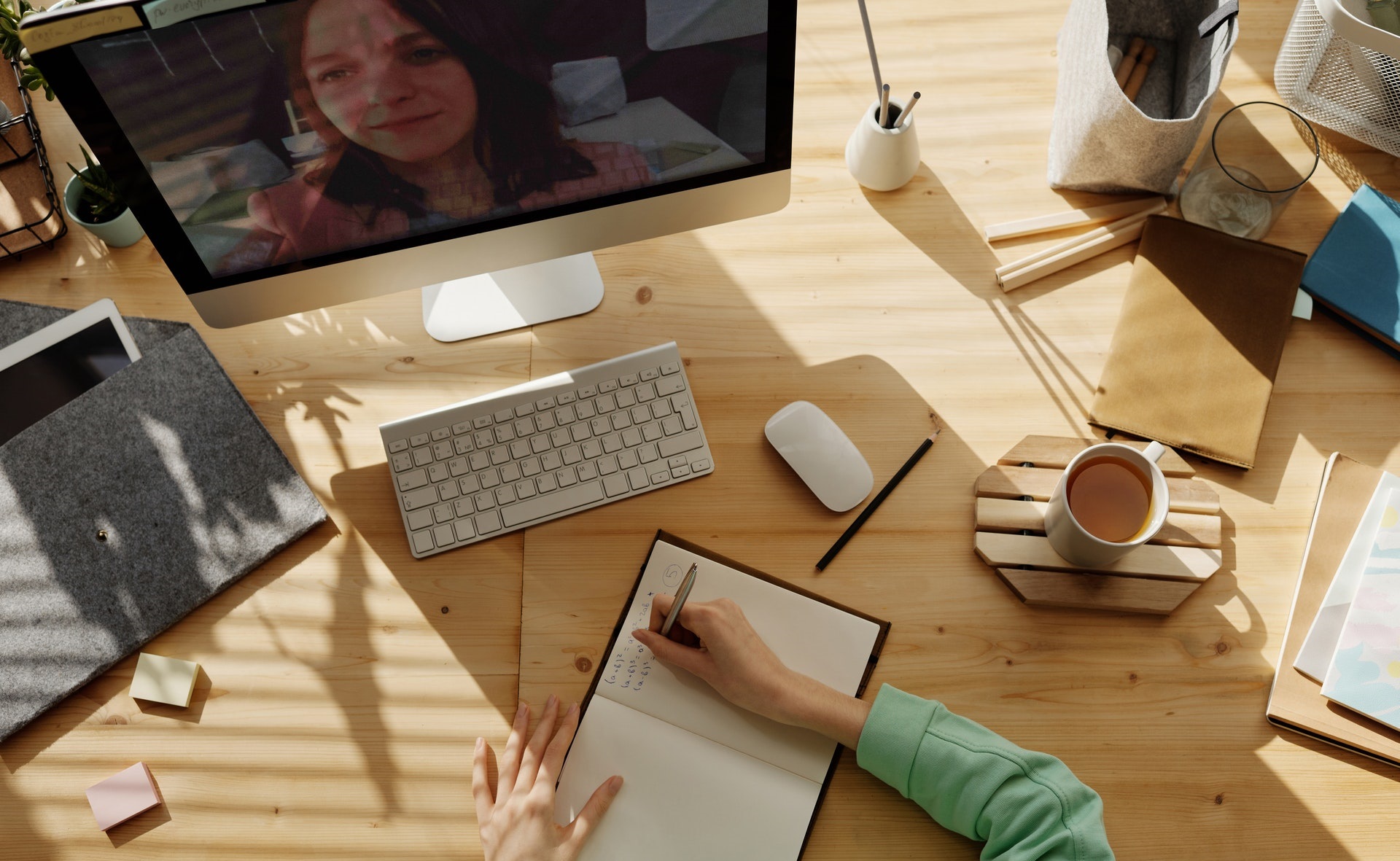 Persona en una videoconferencia tomando apuntes.