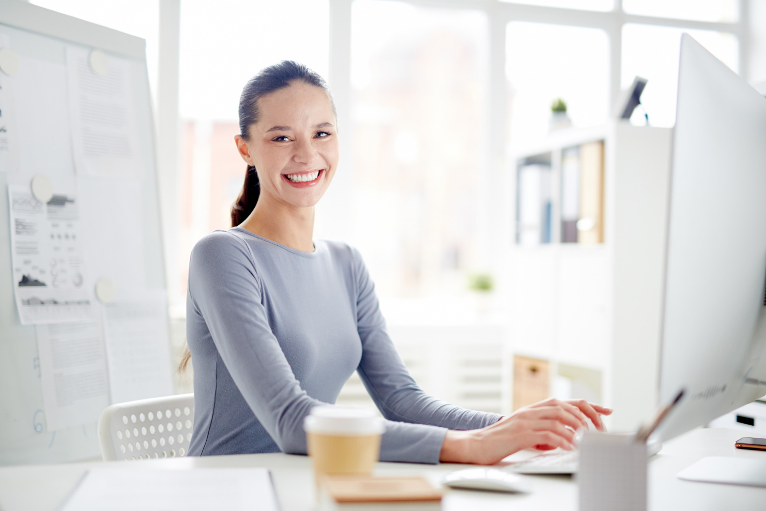 mujer joven sonriendo frente al ordenador