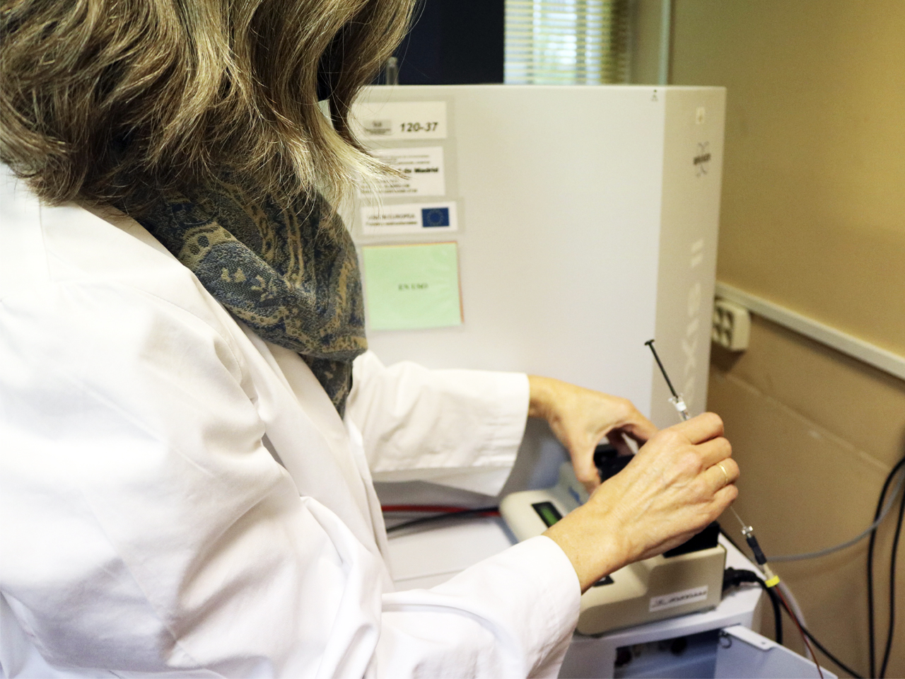 mujer manejando aparato laboratorio