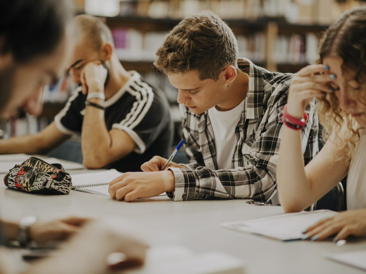 personas estudiando en biblioteca