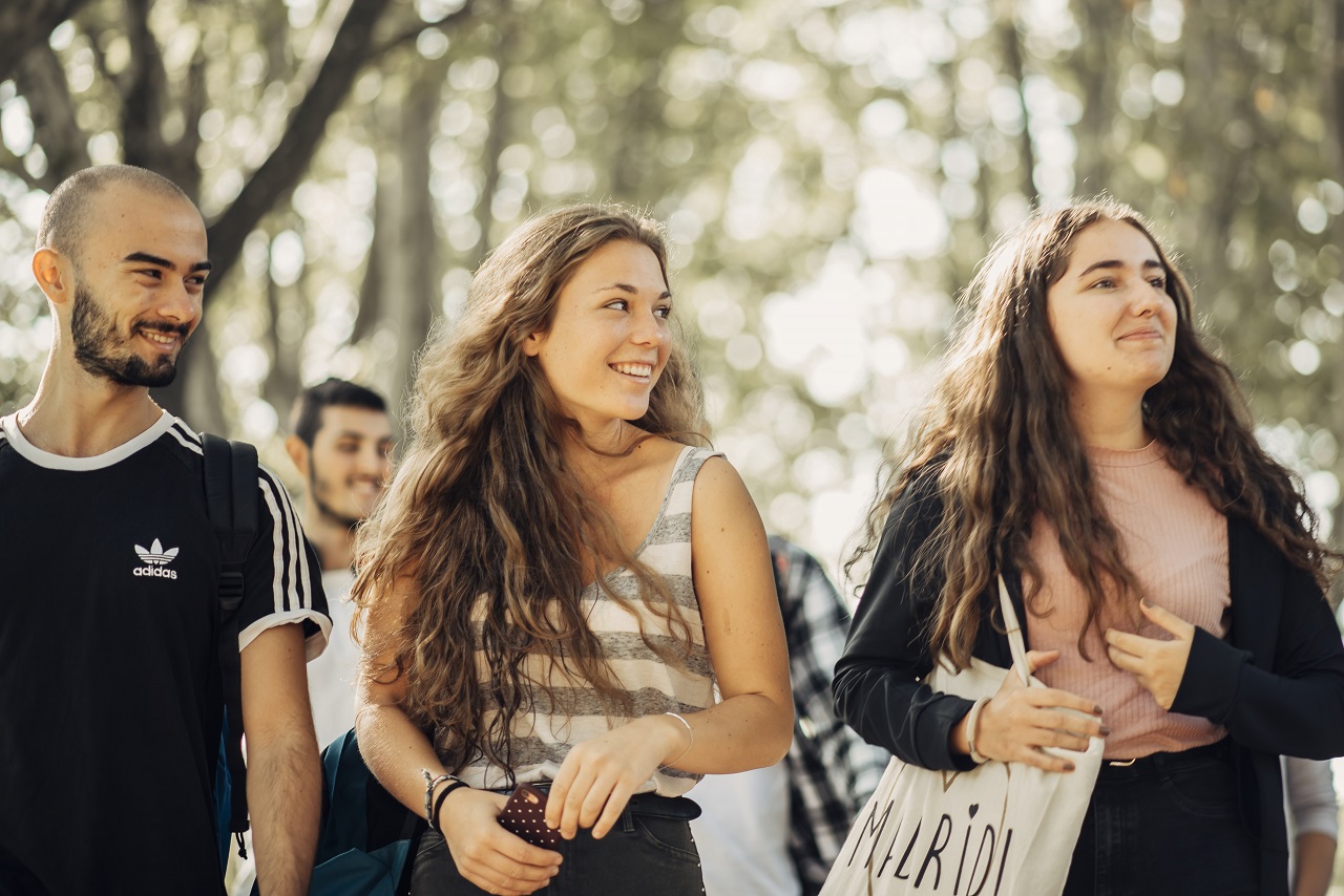 Primer plano de tres estudiantes (un chico y dos chicas) que caminan por el campus de Cantoblanco