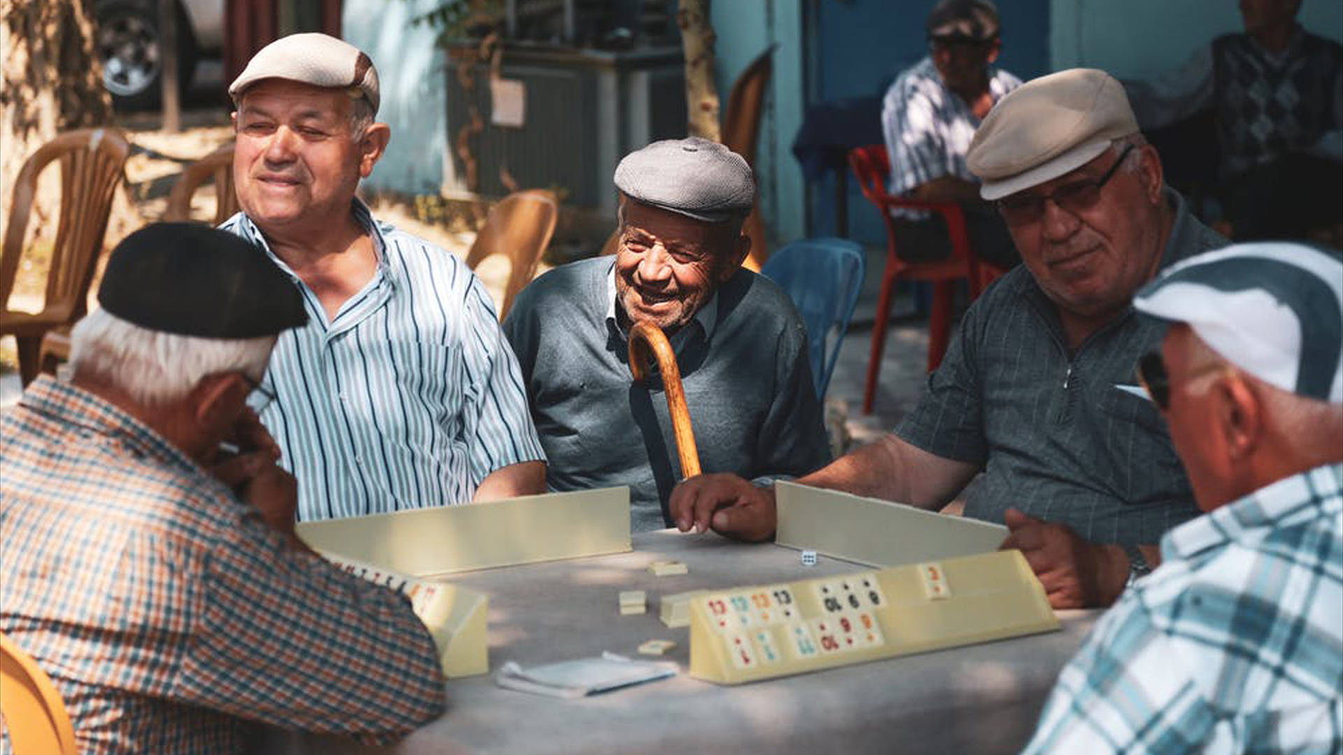 Fotografía que muestra a varias personas mayores jugando juntas en un bar.