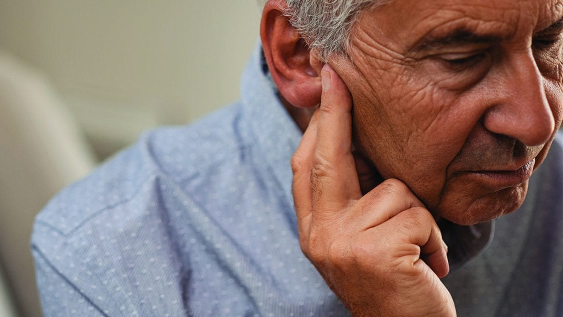 Fotografía en la que una persona mayor se lleva la mano a su oído.