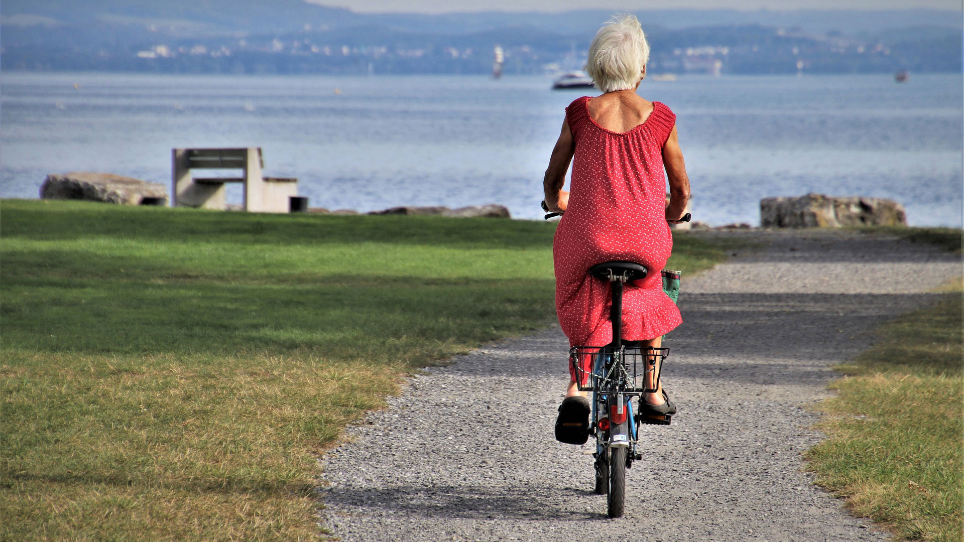 Imagen de una mujer pedaleando frente al mar.