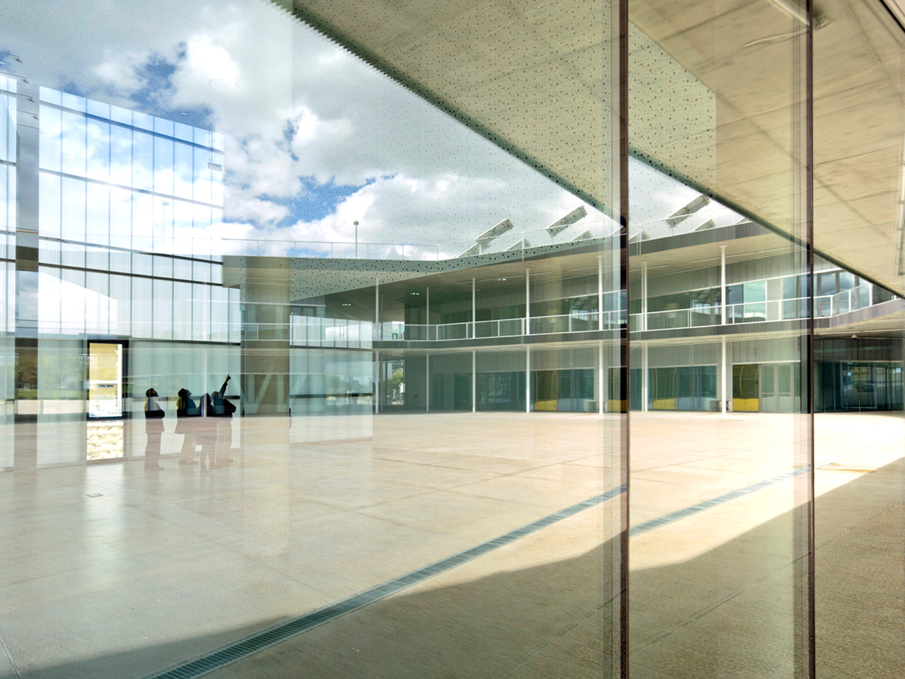 Imagen que muestra la Plaza Mayor de la UAM desde detrás de un cristal 