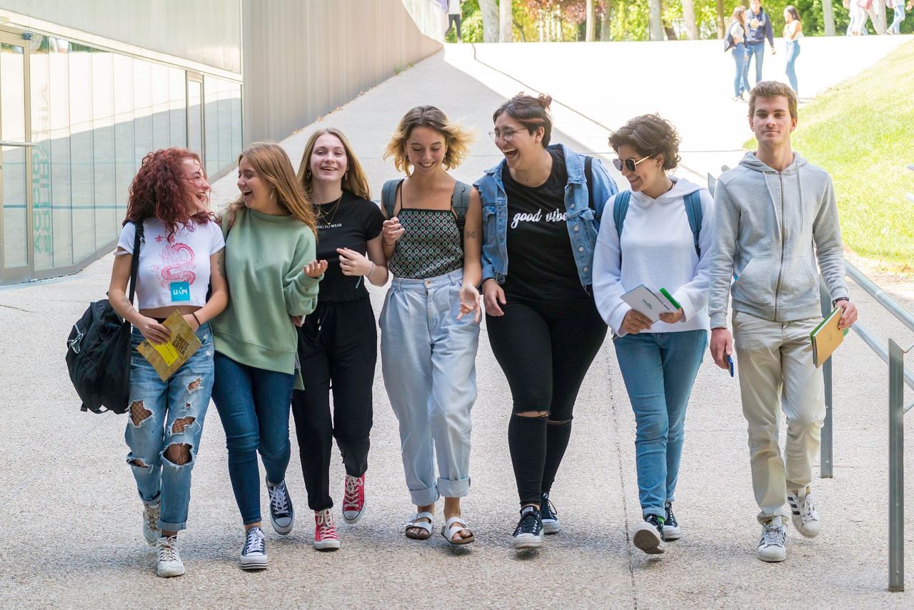 Un grupo de estudiantes sonríen a la cámara sentados en las escaleras del Centro de Estudios de Posgrado