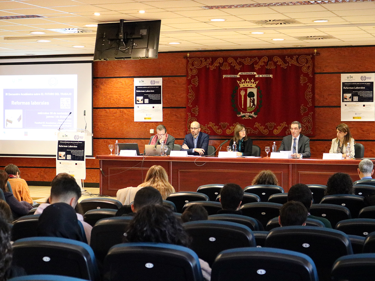 Imagen de la mesa inaugural en la que aparecen sentados de izquierda a derecha: el profesor Santos M. Ruesga, el secretario de Estado de Derechos Sociales, Nacho Álvarez; la rectora Amaya Mendikoetxea, el director de la Oficina de la OIT para España, Félix Peinado y la profesora Ana de la Puebla. 