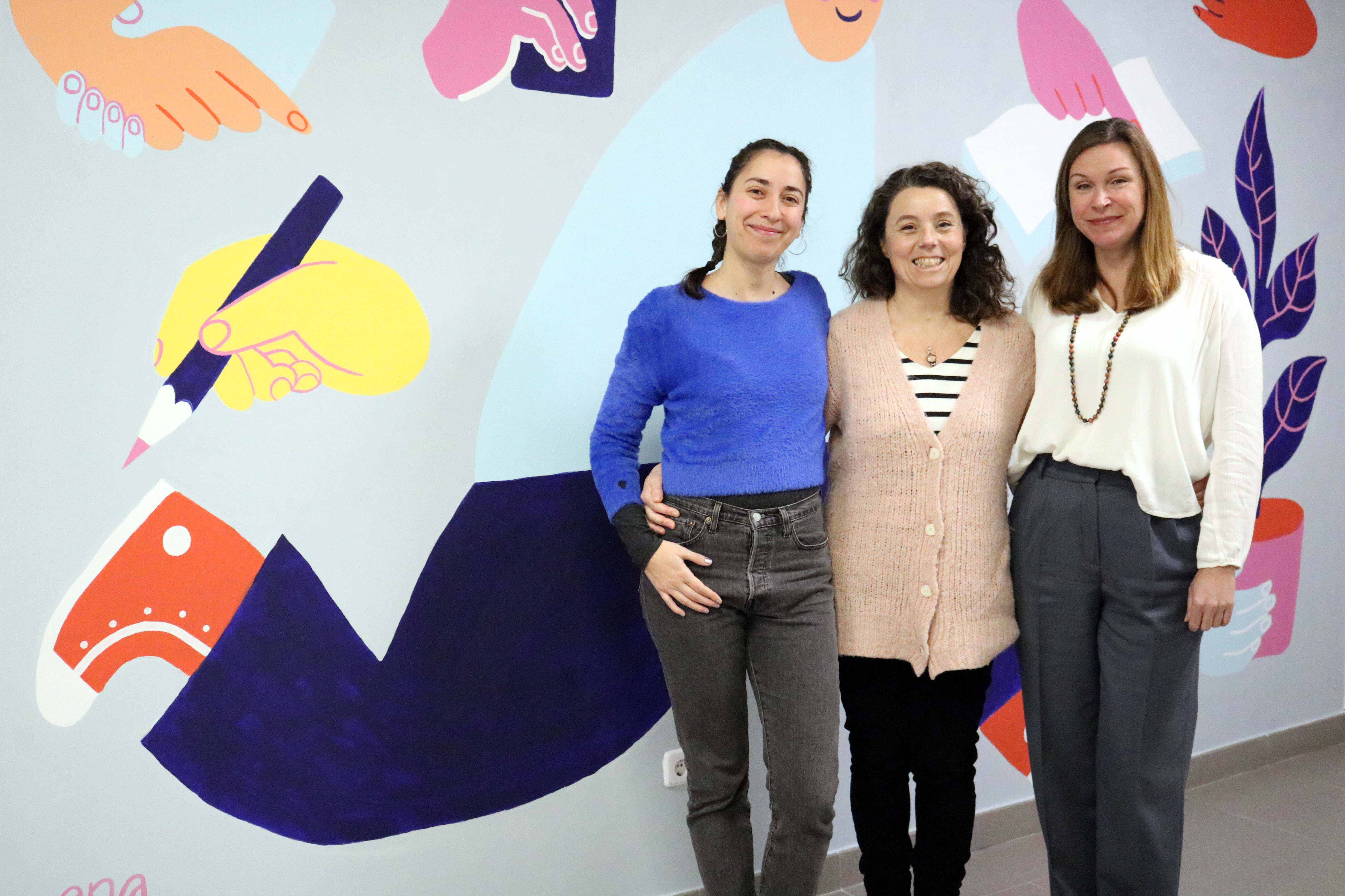 Ana Pez, Eugenia Criado y Nathalie Michaud, junto al mural del Servicio de Idiomas. / UAM
