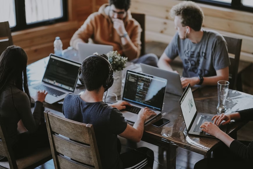 imagen de estudiantes trabajando con sus portátiles en una mesa