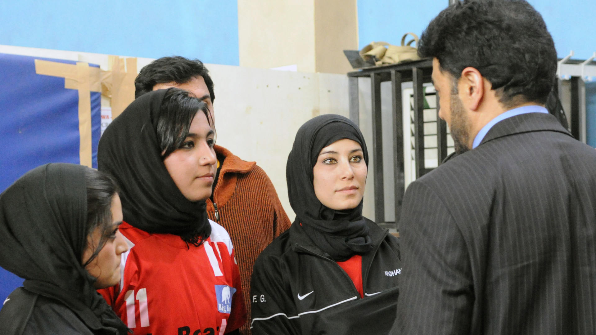 Tres mujeres afganas hablan con el presidente del Comité Olímpico de Afganistán.
