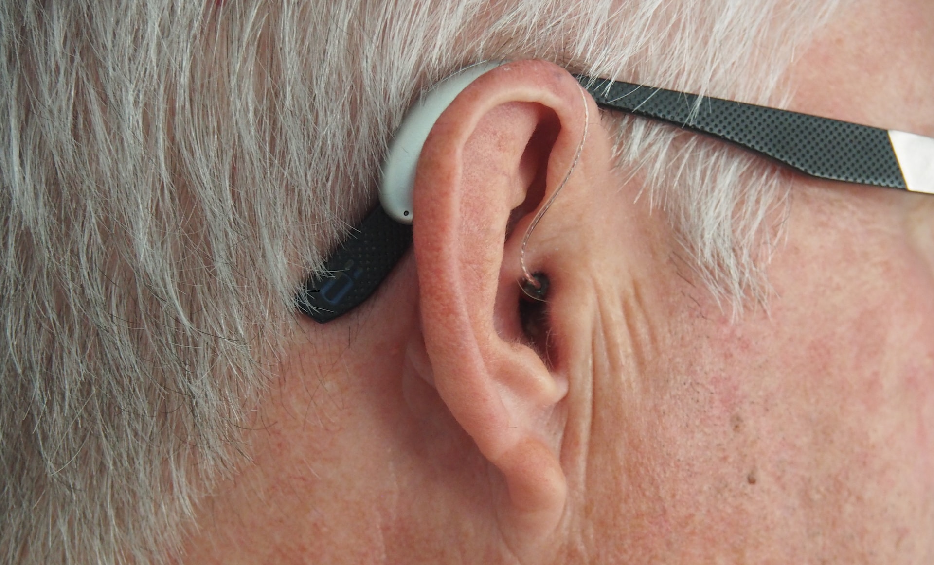 Imagen de una oreja de persona mayor con audífono.