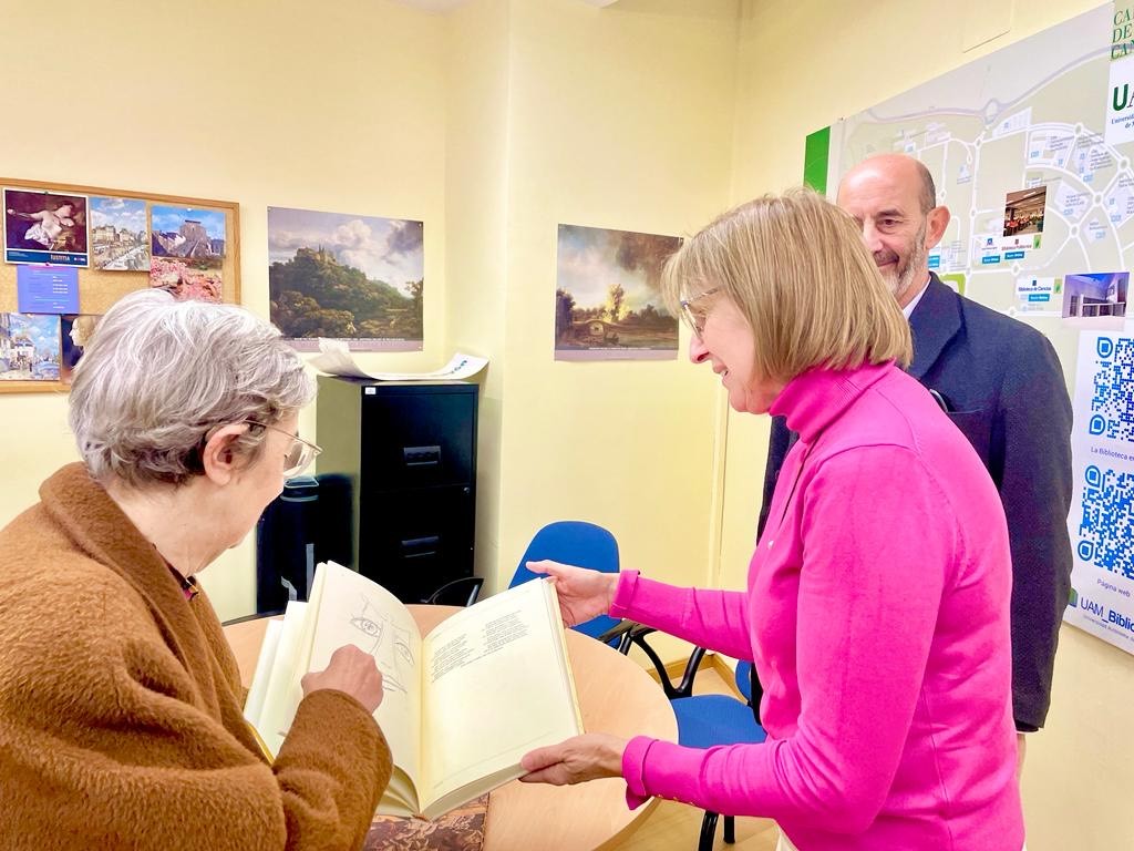 María Purificación García Herguedas entrega su libro a la directora de la Biblioteca de Humanidades, María del Carmen Maestre Plaza, en presencia del profesor de la UAM Lorenzo Bartoli