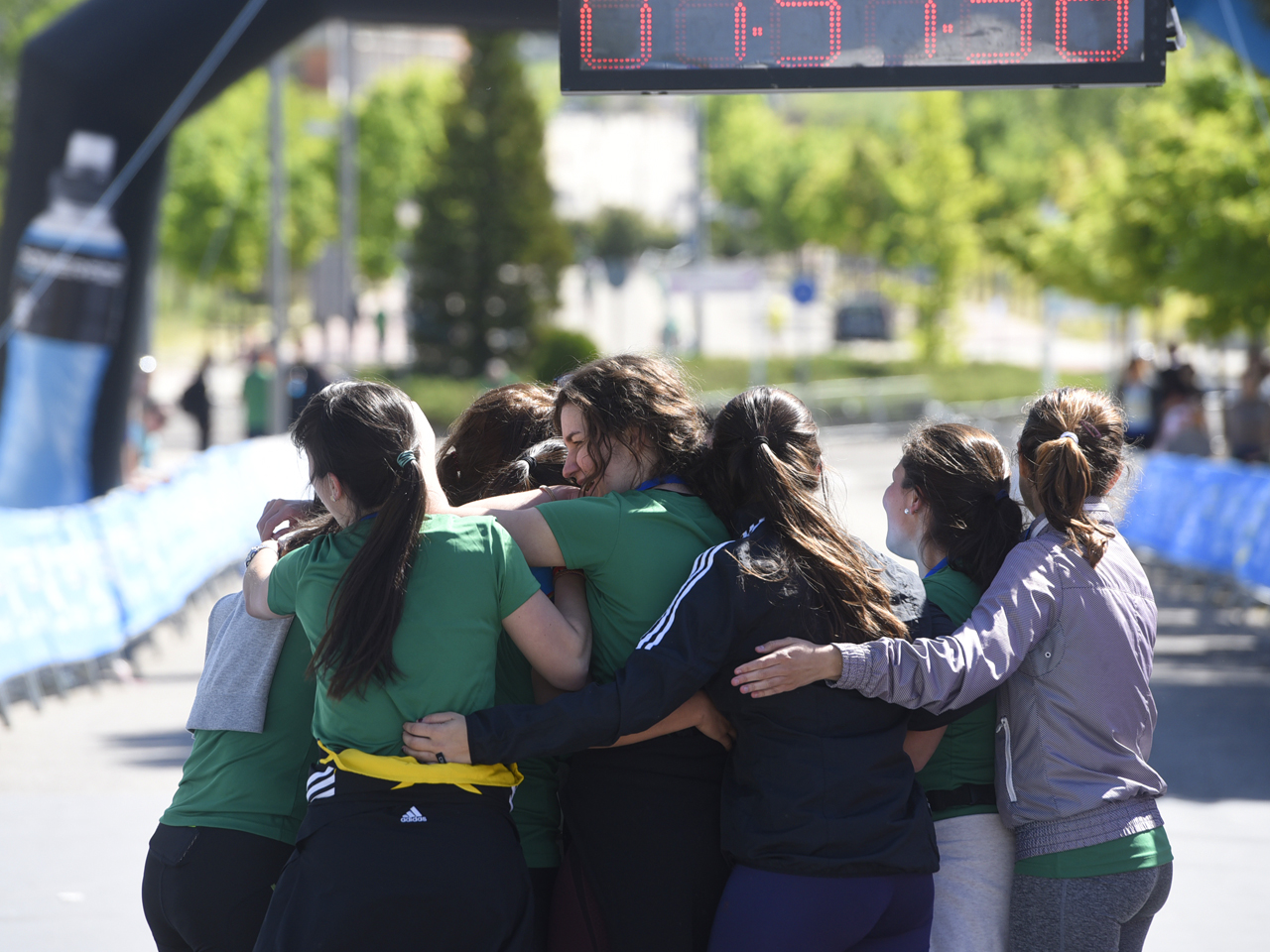 Grupo de estudiantes corredoras abrazándose tras cruzar la meta