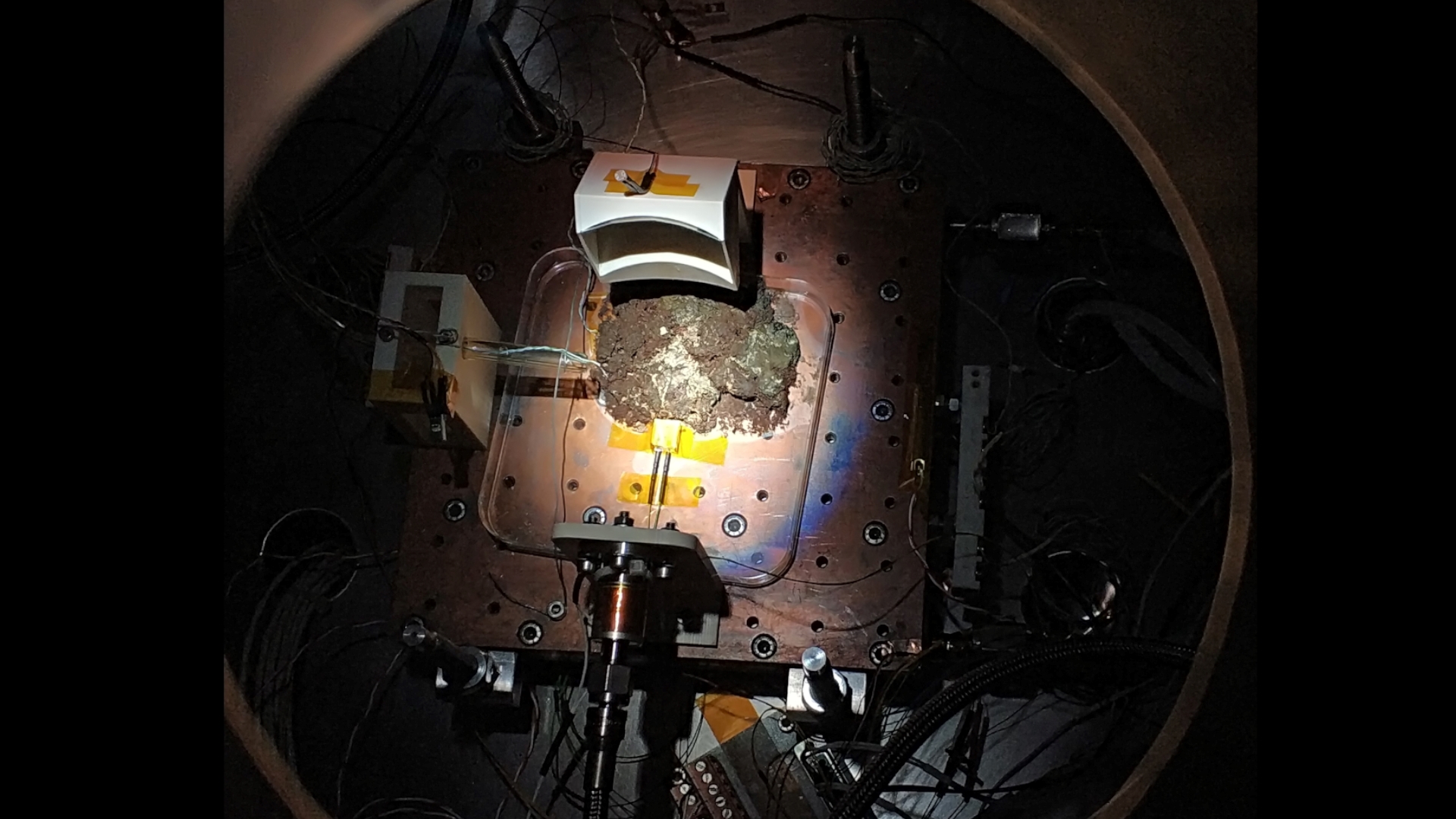 Fotografía de la máquina sobre fondo negro con el foco dirigido a la muestra de microorganismos vivos.