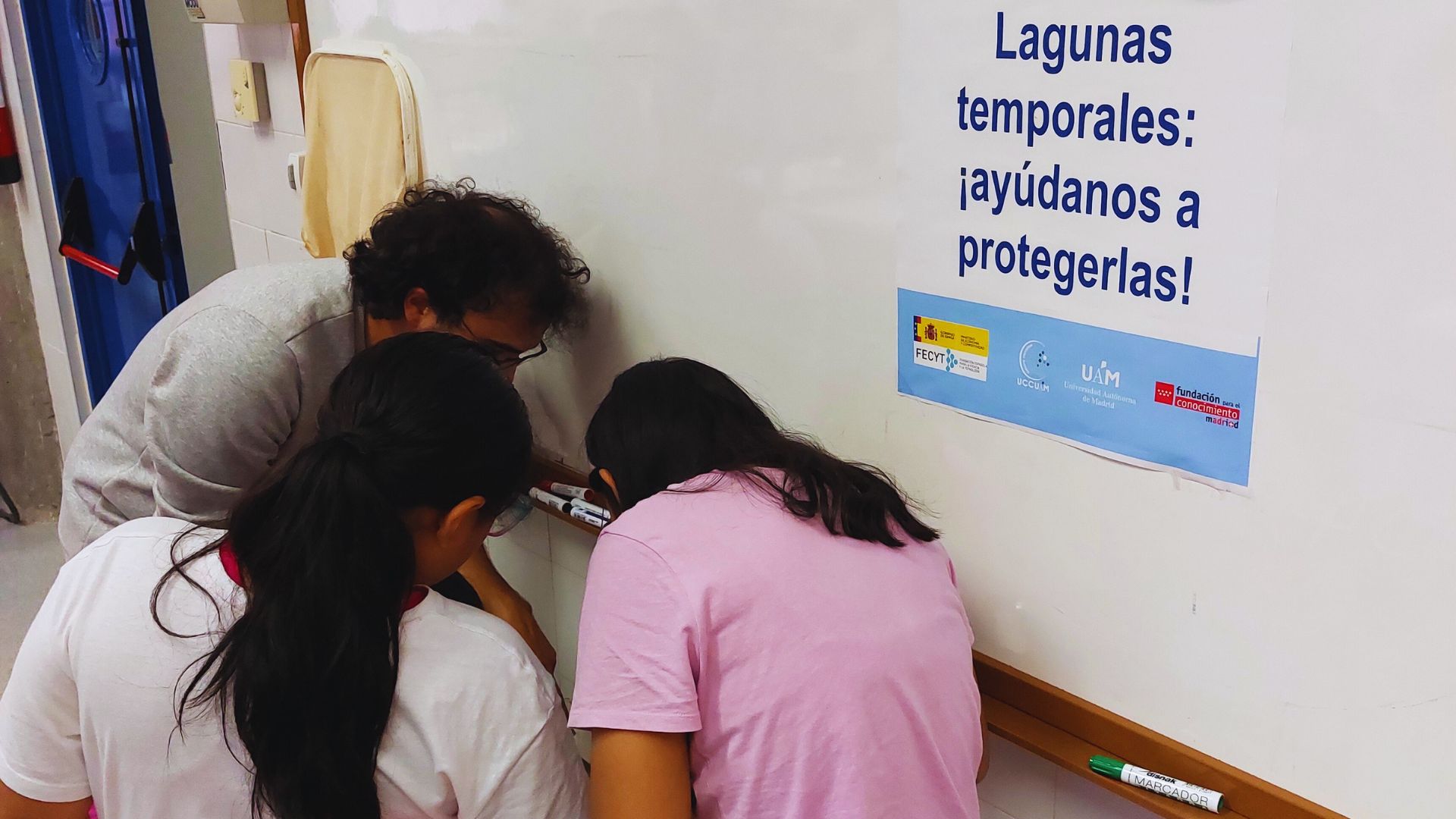 niñas miran a través de una lupa durante la actividad de divulgación
