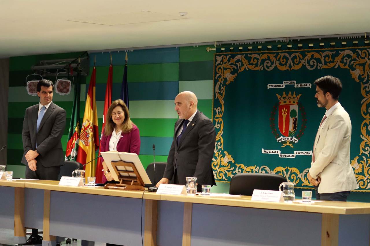 Los miembros de la mesa presidencial aplauden al nuevo decano tras prometer su cargo