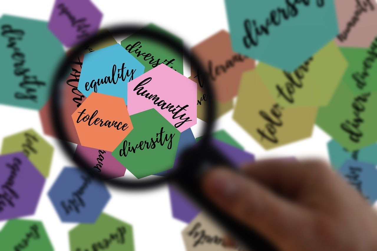 Imagen de recurso que muestra una lupa ampliando palabras relacionadas con la equidad y la diversidad
