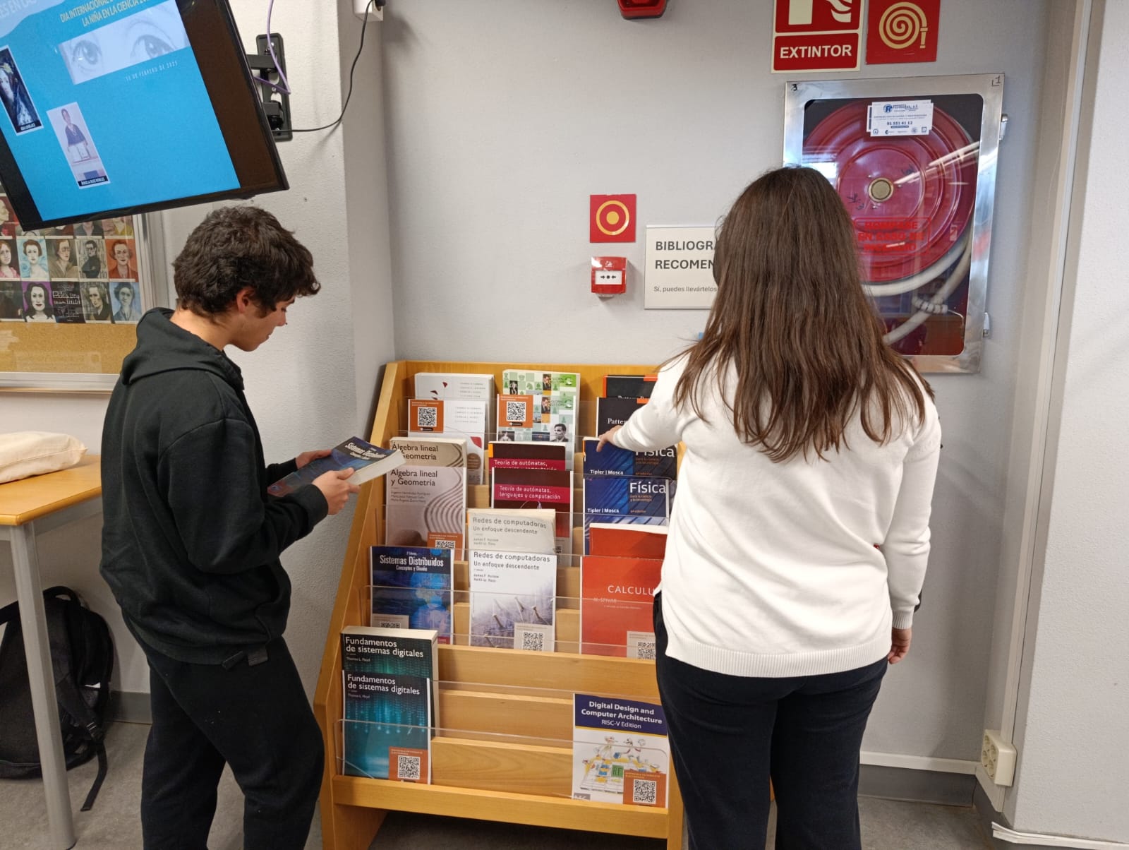 Imagen de dos alumnos consultado la Bibliografía Recomendada.