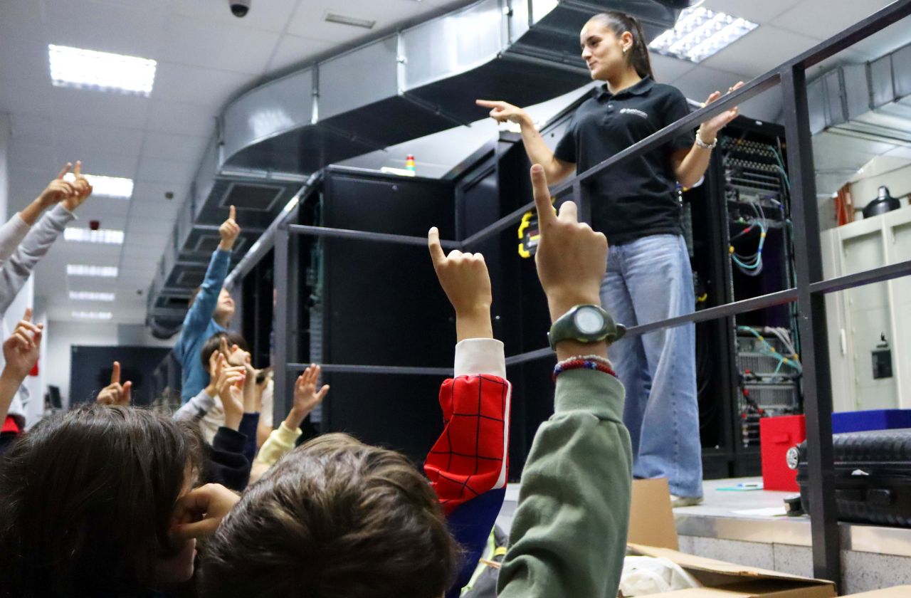 Un grupo de niños y niñas atiende las explicaciones de una técnico en el Centro de Computación Científica de la UAM.
