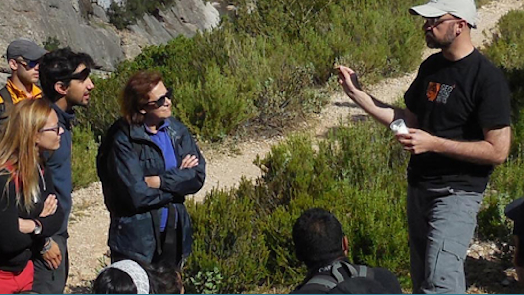 persona en espacio natural dando explicaciones a grupo personas