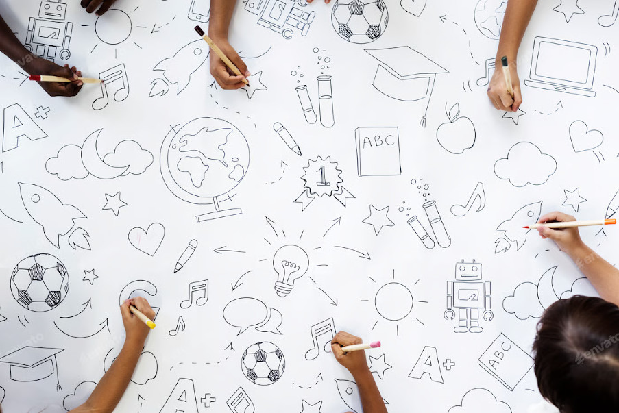 manos de niños pintando sobre un papel 