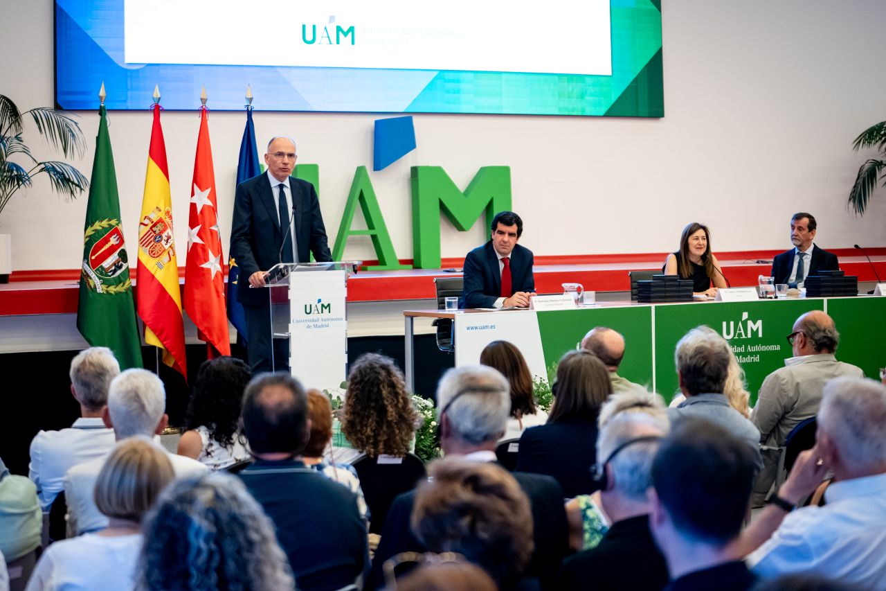 Imagen que muestra a parte del público asistente y, al fondo, el escenario. En el atril, el ex primer ministro de Italia y decano de la Escuela de Políticas, Económicas y Asuntos Internacionales de IE University, Enrico Letta. En la mesa, de izquierda a derecha, el secretario general, Domingo Jesús Jiménez-Valladolid; la rectora Amaya Mendikoetxea y el decano de la Facultad de Ciencias Económicas y Empresariales, Rafael de Arce.