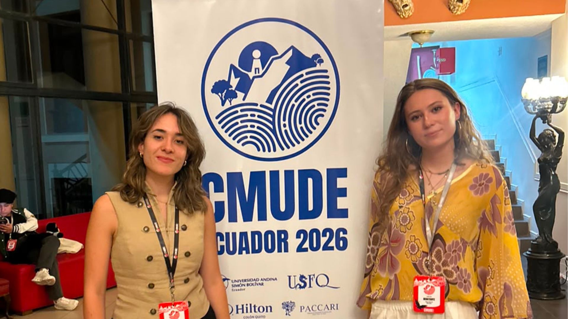 Adriana y Clara con el cartel de CMUDE