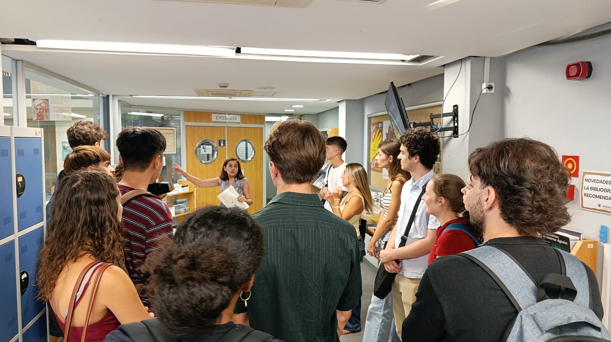 Bibliotecaria explicando el funcionamiento de la Biblioteca a los ERASMUS.
