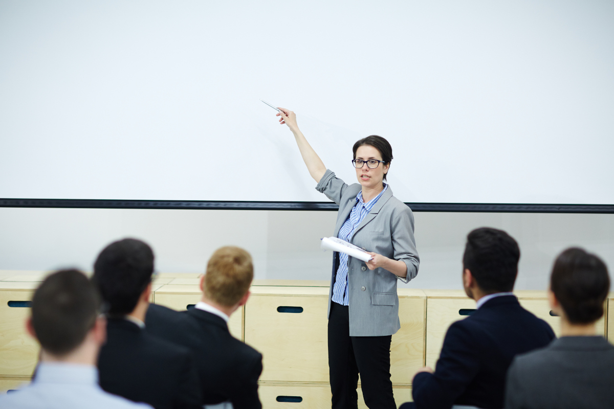 persona en un aula explicando a grupo de personas