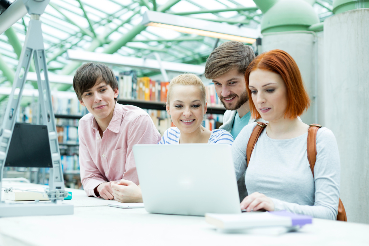 2 mujeres y 2 hombres delante de un portatil